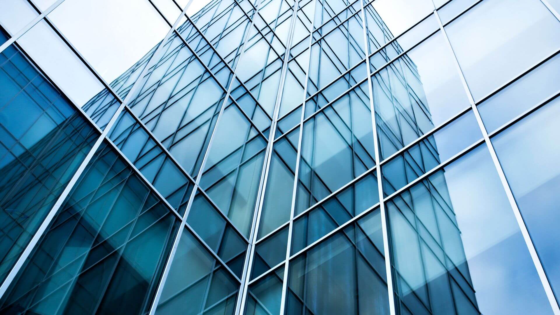 Edifício de vidro refletindo céu